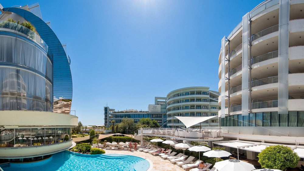 Hotel Premier & Suites, Milano Marittima: piscina esterna, lettini e architettura curva dell'hotel